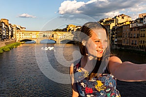 Girl in front of the Ponte Vecchio in Florence, Italy in summer
