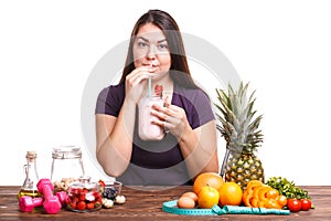 Girl with fruit on the table on a white isolated background