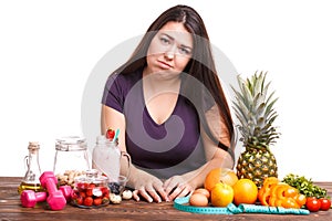 Girl with fruit on the table on a white isolated background