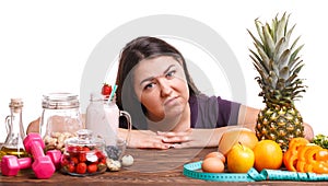 Girl with fruit on the table on a white isolated background