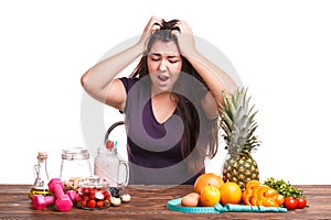 Girl with fruit on the table on a white isolated background