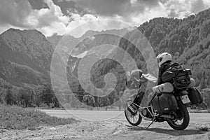 Girl in full body protection, turtle armor, knee pads and helmet, tourer motorcycle for traveling. Copy space, mountains, travel