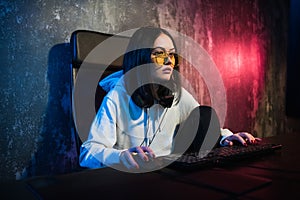Girl gamer wearing headphone playing network games preparing to participate in international competitions in esports