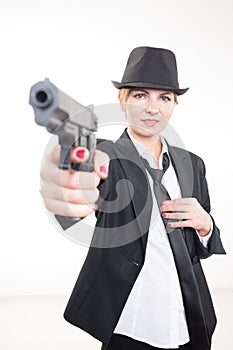 Girl gangster holding a gun. Classic suit and hat.