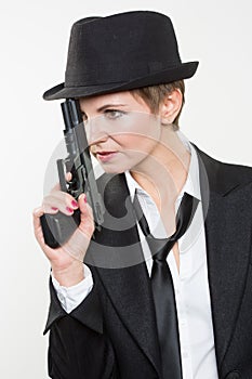 Girl gangster holding a gun. Classic suit and hat.