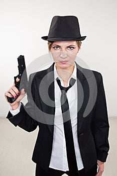 Girl gangster holding a gun. Classic suit and hat.