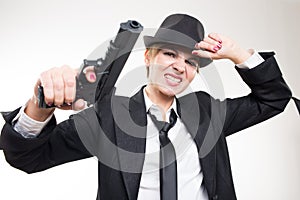 Girl gangster holding a gun. Classic suit and hat.
