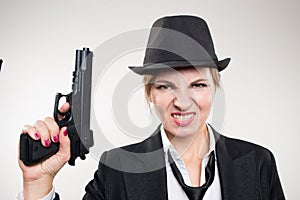 Girl gangster holding a gun. Classic suit and hat.