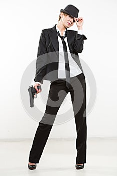 Girl gangster holding a gun. Classic suit and hat.