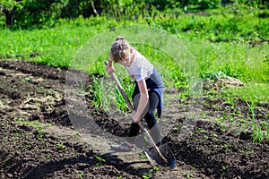 Girl in the garden with a shovel