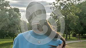 Girl in a gas mask in the rays of the sun. Alienation in the city. Fashion, ecology and loneliness concepts