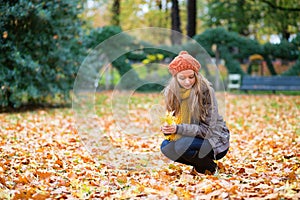 Girl gathering leaves in a park