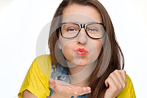 Girl in geek glasses blowing kiss isolated