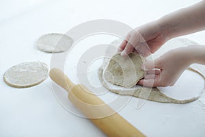 Girl gently sculpts meat pies. hands closeup on table