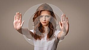 Girl Gesturing Stop Frowning Looking At Camera On Gray Background