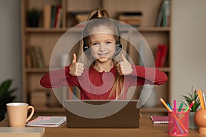 Girl Gesturing Thumbs Up With Both Hands Using Laptop Indoors