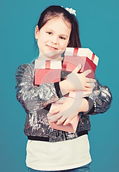 Girl with gift boxes blue background. Black friday. Shopping day. Child carry lot gift boxes. Kids fashion. Surprise