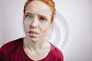 Girl with ginger hair and freckles, looking in camera with angry expression