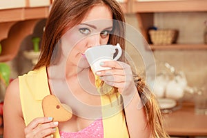 Girl with gingerbread cookies drinking tea coffee.