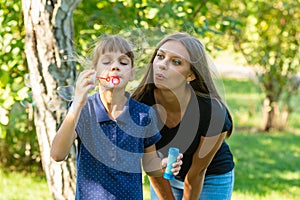 Girl and girl blow bubbles together