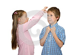Girl gives a flick on boy's forehead, on white photo