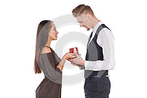 A girl gives her boyfriend a gift box, the guy takes a present. Valentine`s Day. Isolated.