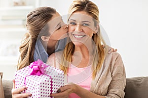 Girl giving birthday present to mother at home