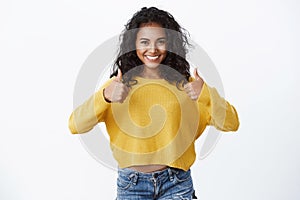 Girl giving her approval like idea. Happy attractive african american young woman in yellow autumn sweater showing