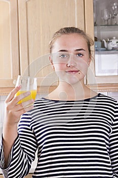 Girl with glass of juice in kitchen