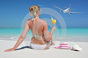 Girl with a glass of orange juice on the beach