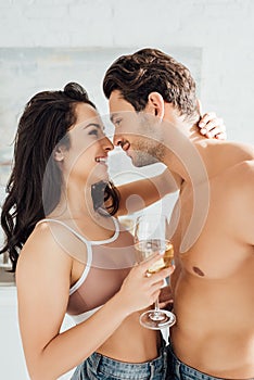 Girl with glass of wine hugging boyfriend and smiling