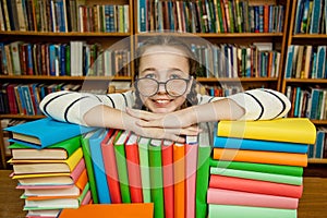 Girl in glasses with books in the library