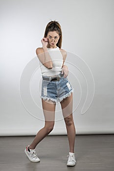 Girl with glasses  in casual outfit posing in studio shot