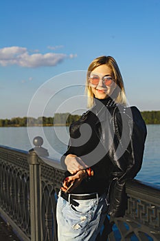 Girl with glasses standing on the waterfront at the fence