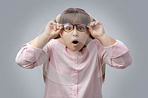 Girl with glasses surprised . disciple shocked. gray background .