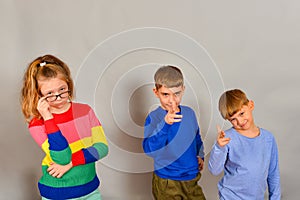 The girl with glasses and two boys point fingers forward, disposing to action. The concept of advertising and services