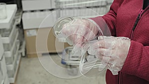 Girl in gloves against virus buy glass for martinis and cocktails in store