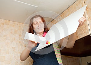 Girl glues ceiling tile