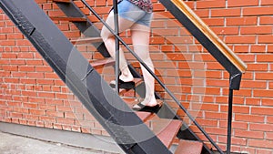 Girl go up by industrial stairs