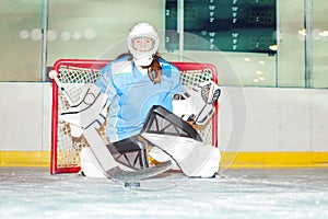 Girl goaltender crouches in crease to protect net photo