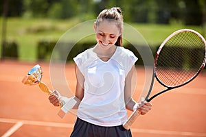 Girl with goblet on tennis court