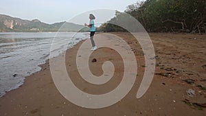 Girl goes at jog trot along beach at sunrise