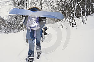 The girl goes with a snowboard on a snowy slope