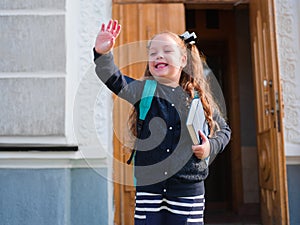 The girl goes to school with a briefcase and a book