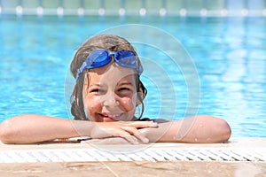 Girl in goggles on forehead swimming in pool