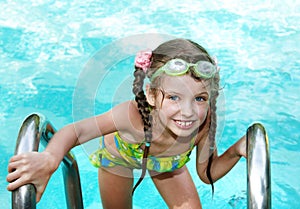 Girl in goggles leaves pool.