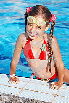 Girl with goggles, red swimsuit in swimming pool