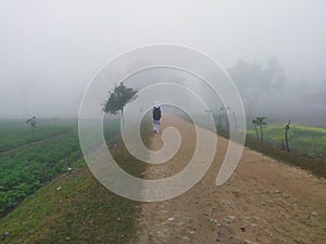 The girl is going through a foggy road.On a frigid winter morning.School Girl