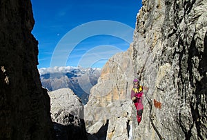 Girl going the mountain via ferrata in Dolomite Alps