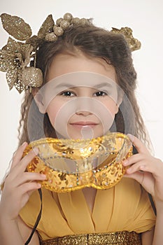 Girl in a gold with a carnival mask